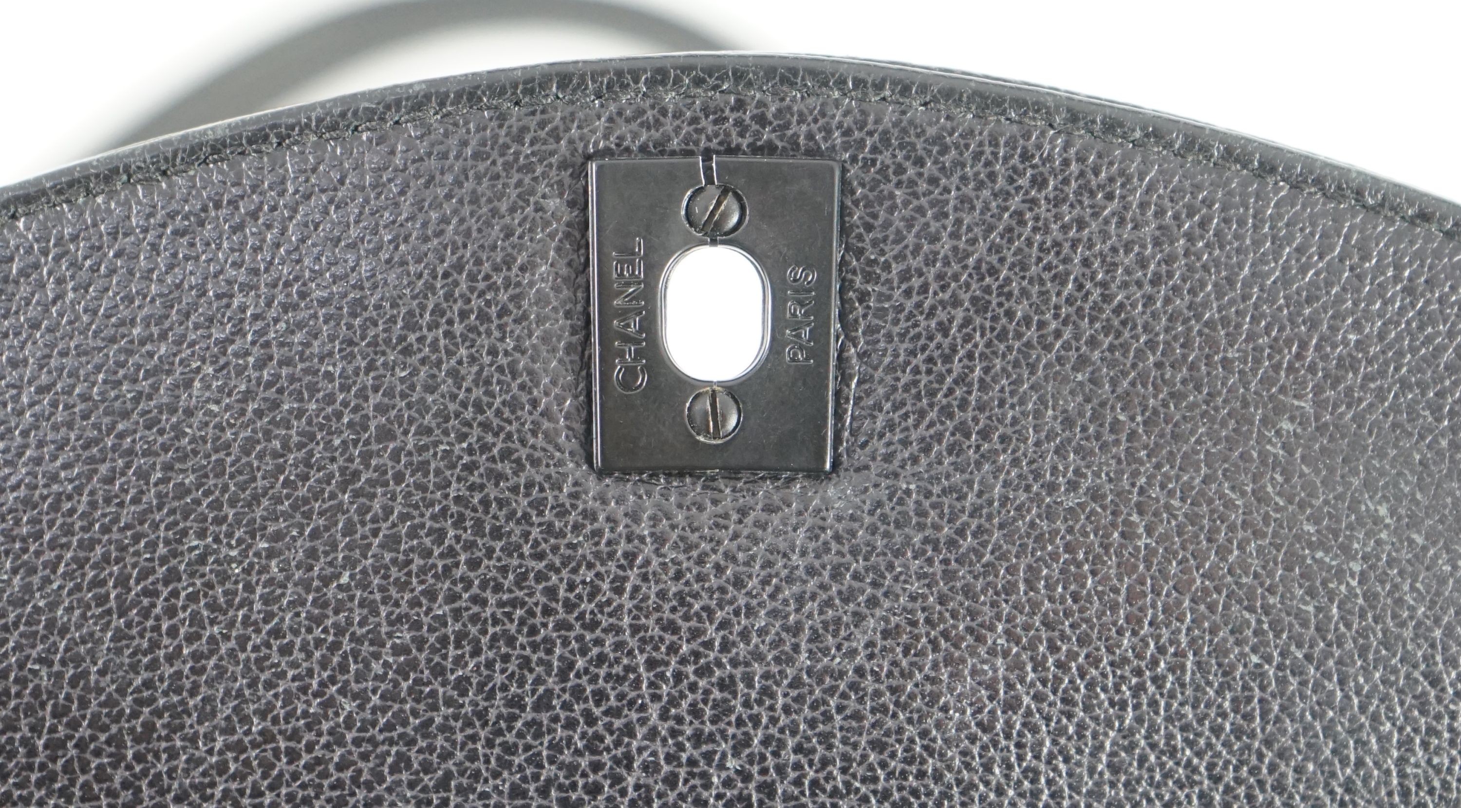 A black Chanel shoulder bag with two straps and Chanel logo lock